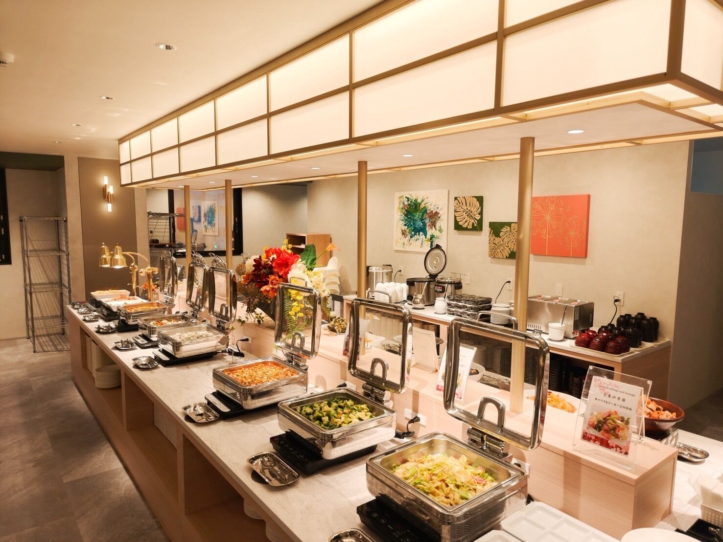 A buffet setup with various food stations, including salads, pasta, and hot dishes, in a modern hotel setting.