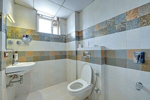 Een badkamer met toilet, wastafel en douche.