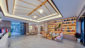 Eine geräumige Lobby mit einem Holzbühne-Empfangsbereich, Sitzgelegenheiten und einer Bücherwand.