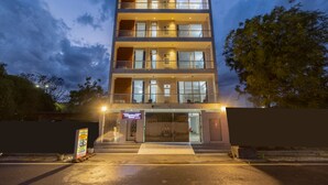 A multi-story hotel with balconies, large windows, and a well-lit entrance. - Yashobhoomi Suites near Yashobhoomi Convention Centre (New Delhi)