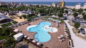 A resort with a large swimming pool, beach access, and a view of the sea. - Friendly Mobile Home in Rimini Family Village (Rimini)