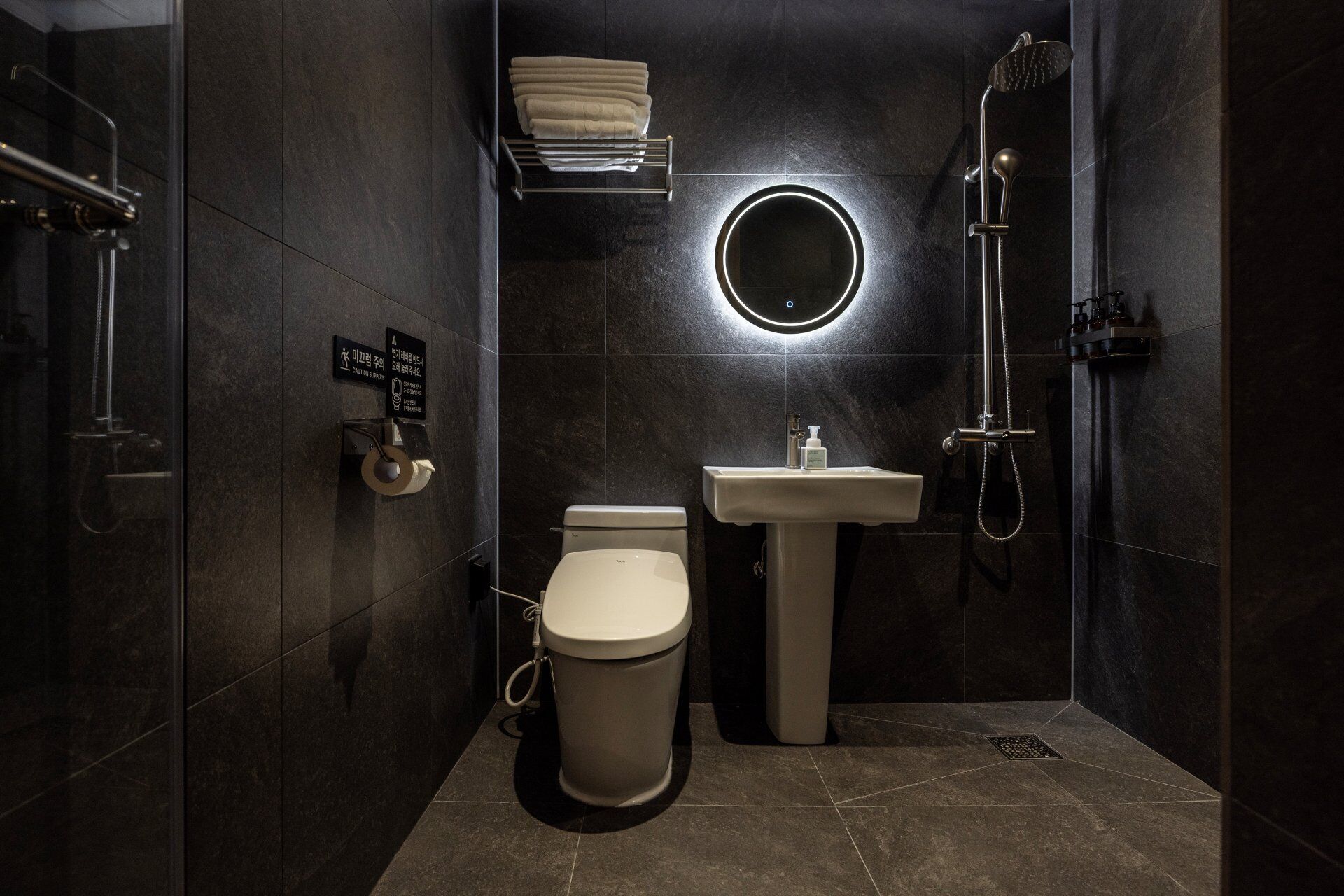 A modern bathroom with a toilet, sink, and shower.
