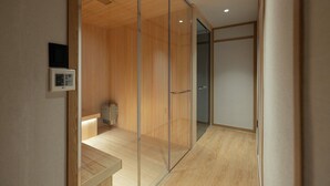 Una habitación de hotel moderna con suelo de madera, un separador de vidrio y un calefactor empotrado.