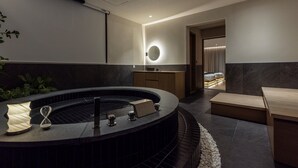 Un baño moderno con una bañera independiente, un espejo y un tocador de madera.