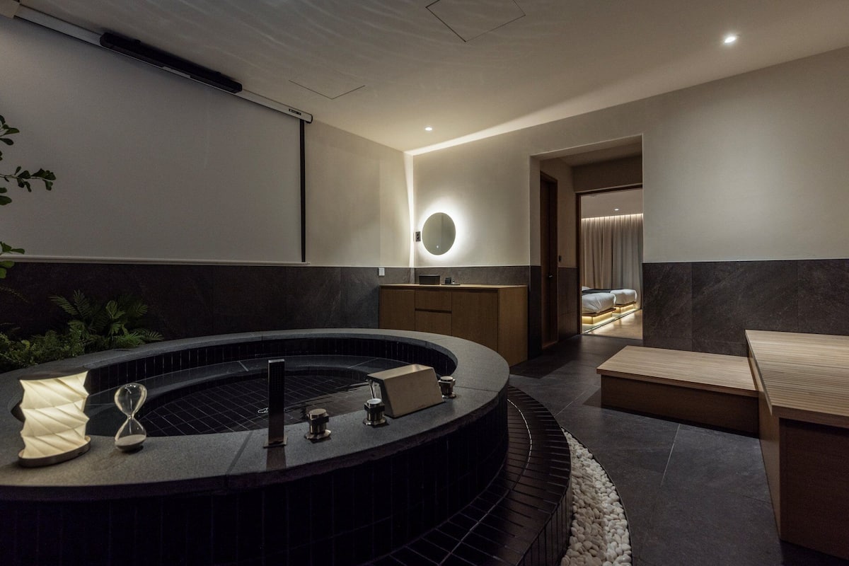 A modern bathroom with a freestanding bathtub, a mirror, and a wooden vanity.