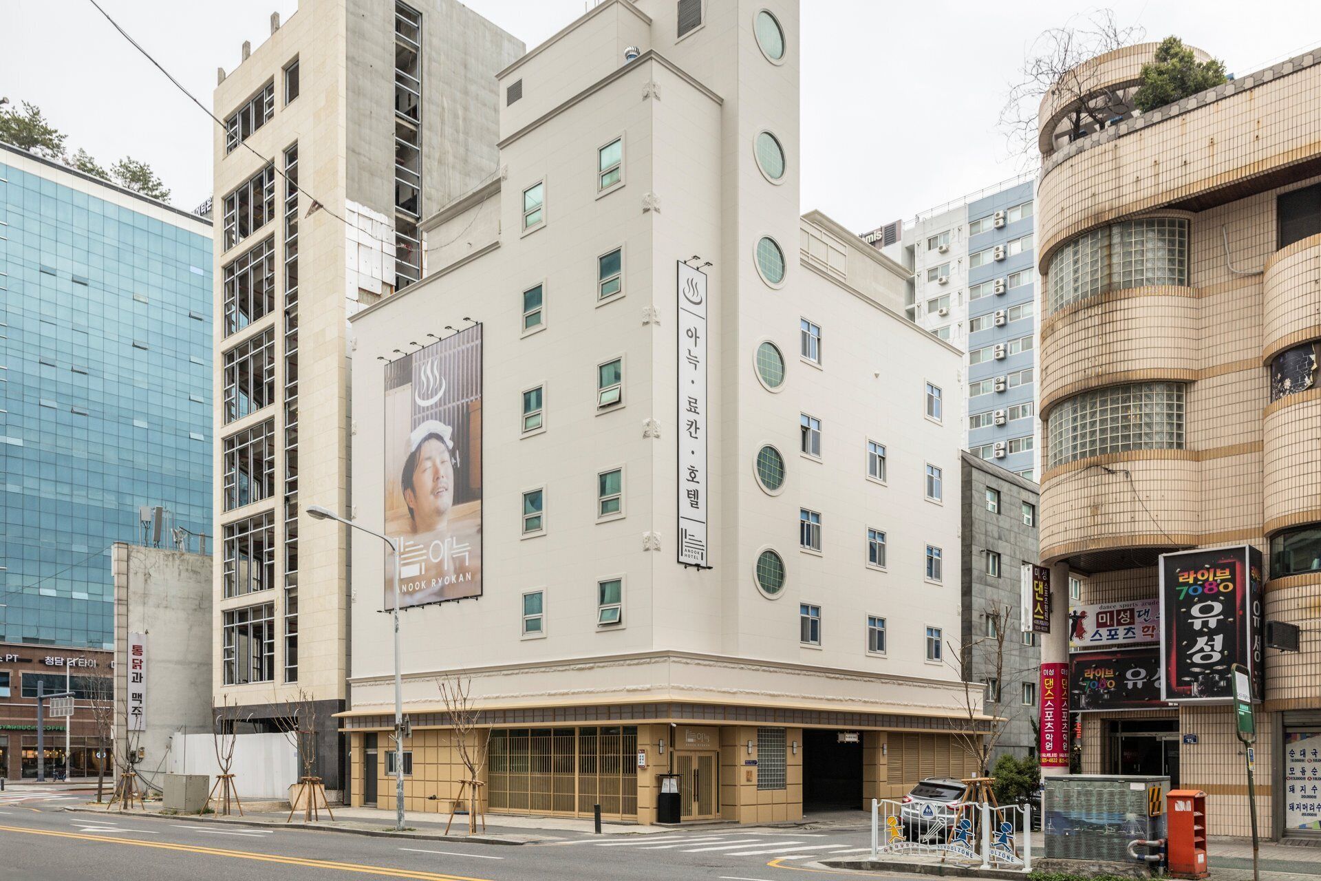 Un hôtel doté d’une façade moderne, de plusieurs étages et d’une grande enseigne publicitaire sur le côté.