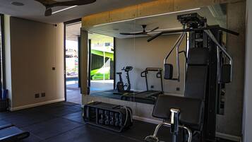 Une salle de sport moderne équipée de matériel d’exercice, de supports pour les poids et d’un miroir.