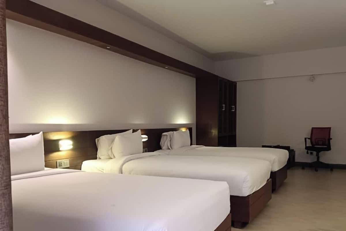 Ett hotellrum med två sängar, ett skrivbord och en stol.