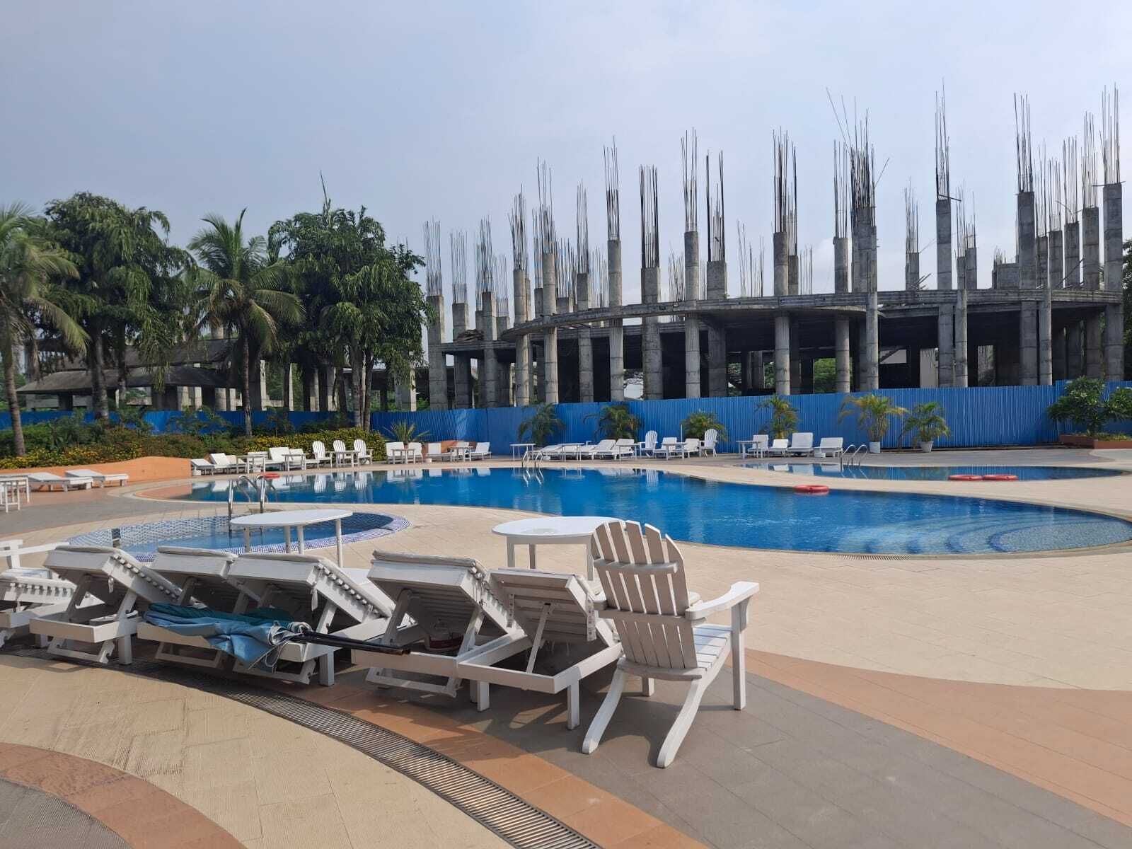 Una piscina con lettini e vista su un edificio con colonne.