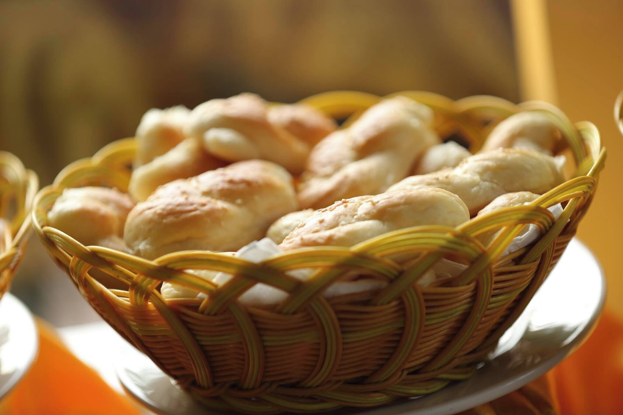 A basket of bread rolls on a plate.