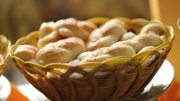 A basket of bread rolls on a plate.