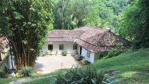 A house with a tiled roof, surrounded by lush greenery and a well-maintained lawn. - Leonora House, Talpe (Galle)