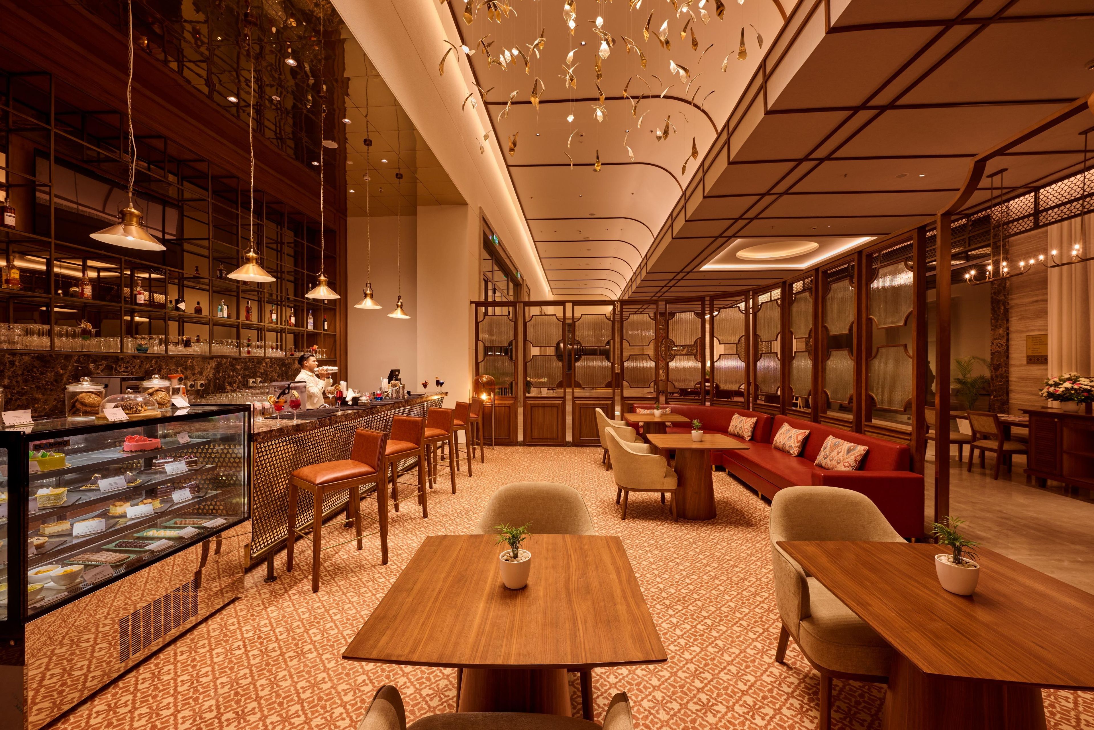 Un intérieur moderne avec un bar, des espaces aménagés pour s’asseoir et un sol à motifs.