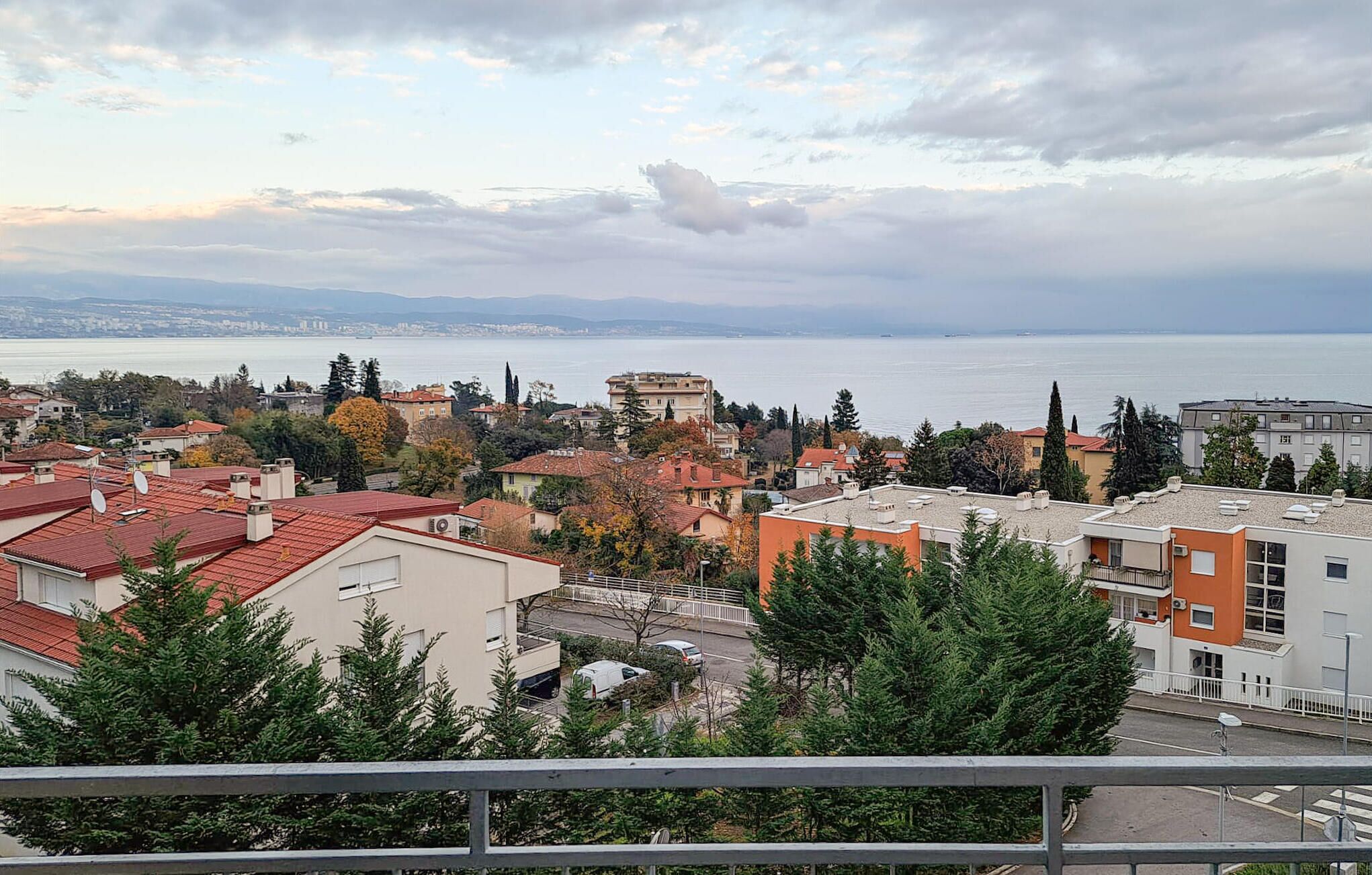 Eine Küstenstadt mit Gebäuden, Bäumen und Blick aufs Meer.