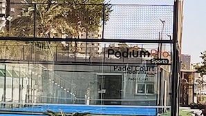 L’entrée d’un complexe sportif, avec une enseigne indiquant « Padium Pro Sports » et « Terrain de padel ».