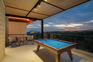 A pool table with chairs on a balcony overlooking a scenic view. - Cloud Nine Ungasan | 5-Bedroom Pool Villa, Uluwatu (Bali)