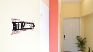 A hallway with a sign pointing to the Airbnb. - Gated Serenity: 5-Star Secure Studio in MoBay, 10-Min Drive to Beach! (Montego Bay)