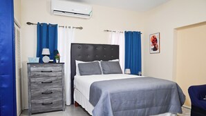 A neatly arranged bedroom with a bed, a dresser, and a chair. - Gated Serenity: 5-Star Secure Studio in MoBay, 10-Min Drive to Beach! (Montego Bay)