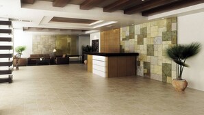 Eine großzügige Lobby mit einer Rezeption, einer Steinwand und einer Treppe.
