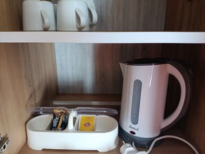 A kitchen area with a white kettle, a coffee maker, and a coffee pod holder. - MoCa Hotel Suite 1 Power 220V & Luxury Design (Beldibi Bahçecik)