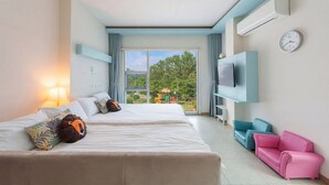 Een hotelkamer met twee bedden, een televisie, een roze bank en uitzicht op een speeltuin.
