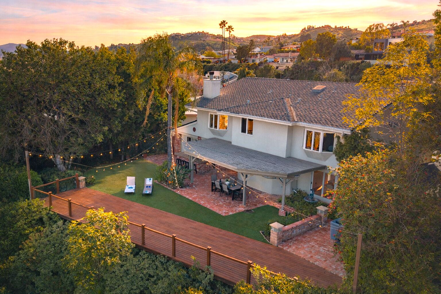 Golden-hour glow at your private retreat—string lights, spacious yard, and effortless indoor-outdoor living.