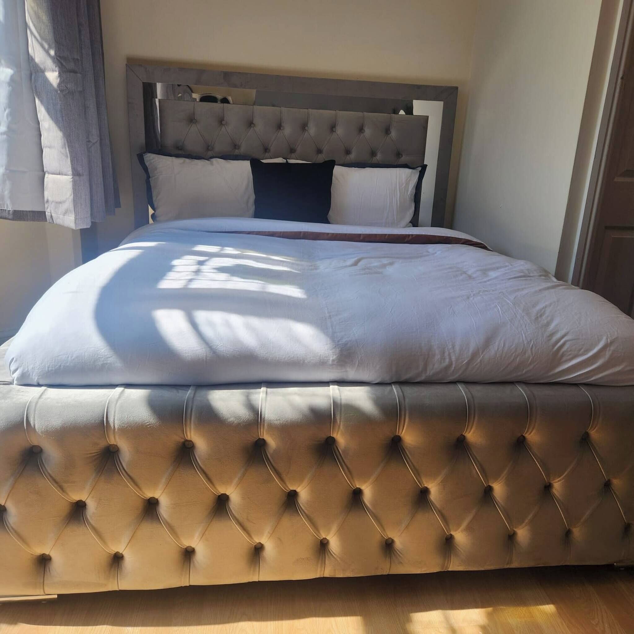 A bed with a tufted headboard and a large, padded mattress.