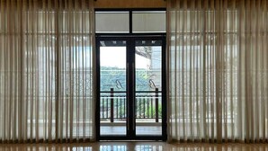Un'ampia hall con pavimento lucido, un'ampia porta in vetro con segnale di uscita e vista sul verde circostante.
