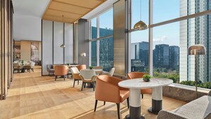 Un intérieur moderne avec de grandes fenêtres, un coin repas et un espace salon.