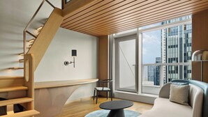 Un intérieur moderne avec un escalier, un canapé, une table et une chaise.