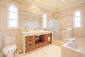 Un bagno con toilette, lavandino, mobile lavabo e vasca.