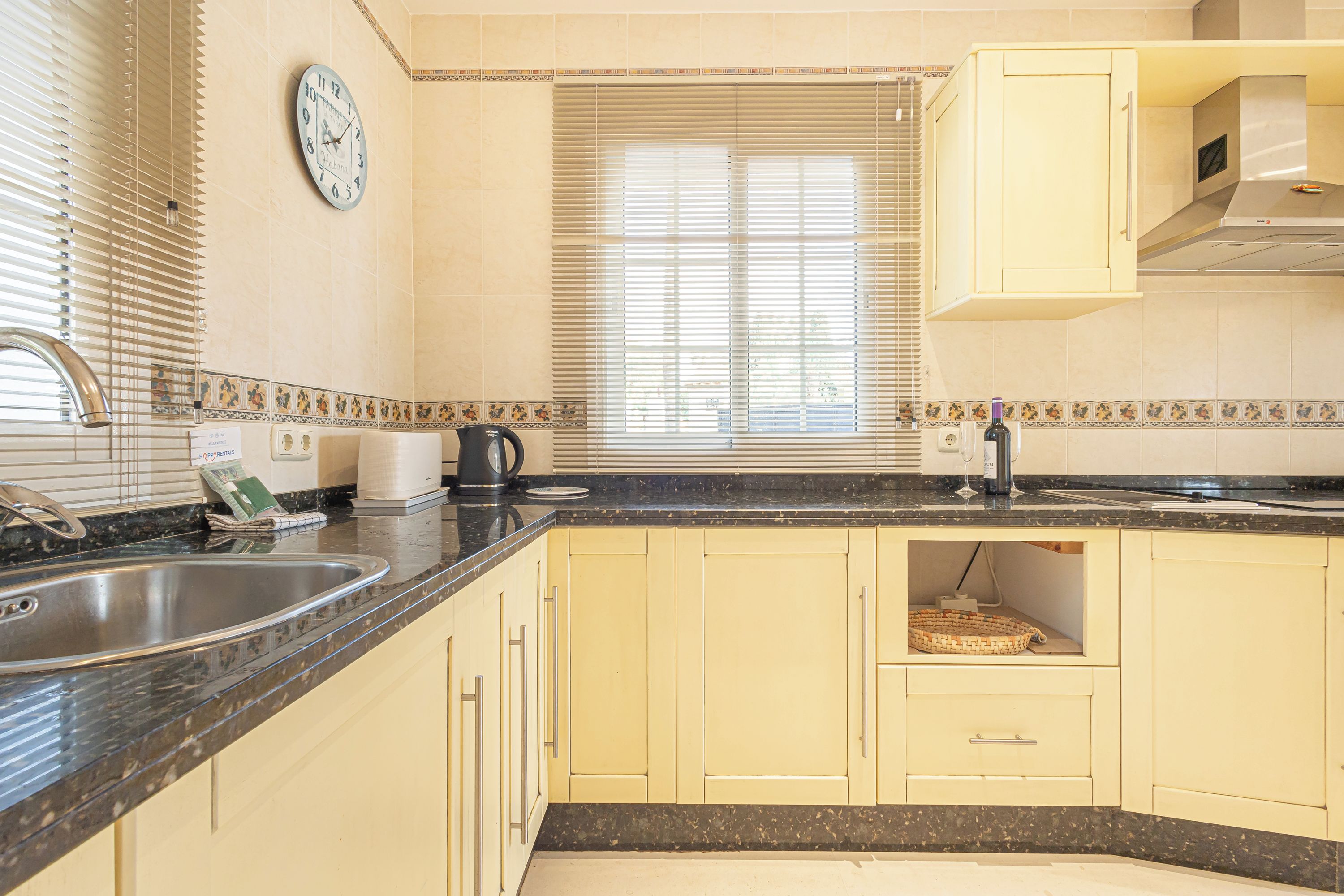 A kitchen with a sink, stove, and cabinets.