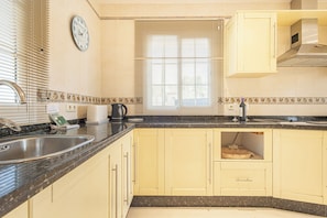 A kitchen with a sink, stove, and cabinets. - Family Villa for 7 Mijas Golf With Pool (Mijas)