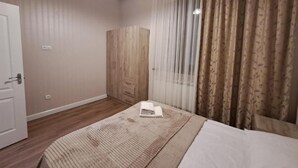 Una habitación de hotel con una cama, un armario y una puerta.