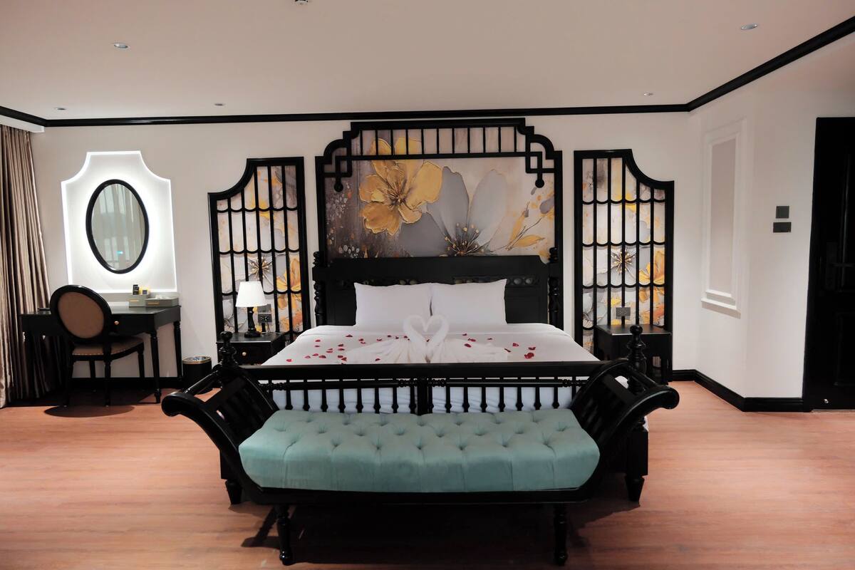 Un dormitorio con cama, escritorio, silla y un adorno en la pared.