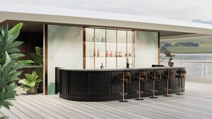 A modern bar area with a marble countertop, bar stools, and a view of the lake. - HALORA NOVA LUXURY CRUISE (Bai Chay)
