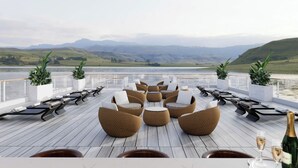 A deck with wicker furniture, a table, and a bottle of champagne. - HALORA NOVA LUXURY CRUISE (Bai Chay)
