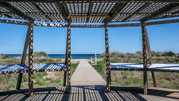 A wooden boardwalk leading to a beach with a pergola structure providing shade. - Stunning apartment in Cabanes with swimming pool (Cabanes)