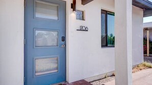 A blue door with a frosted glass panel, a house number '1706', and a small window with a view of greenery. - The Montecito Midpoint — spacious — 100" TV (Phoenix)