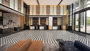 A modern lobby with a checkered floor, a sofa, a coffee table, and a reception desk.
