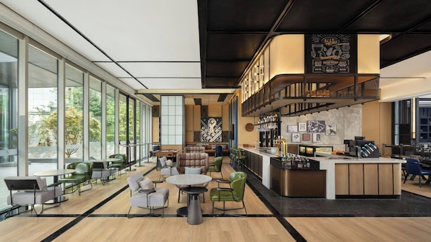 A modern bar area with a menu, seating with tables and chairs, and a counter.