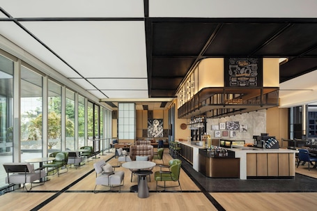 A modern bar area with a menu, seating with tables and chairs, and a counter with a barista station.. Four Points by Sheraton Chongqing Jiangjin