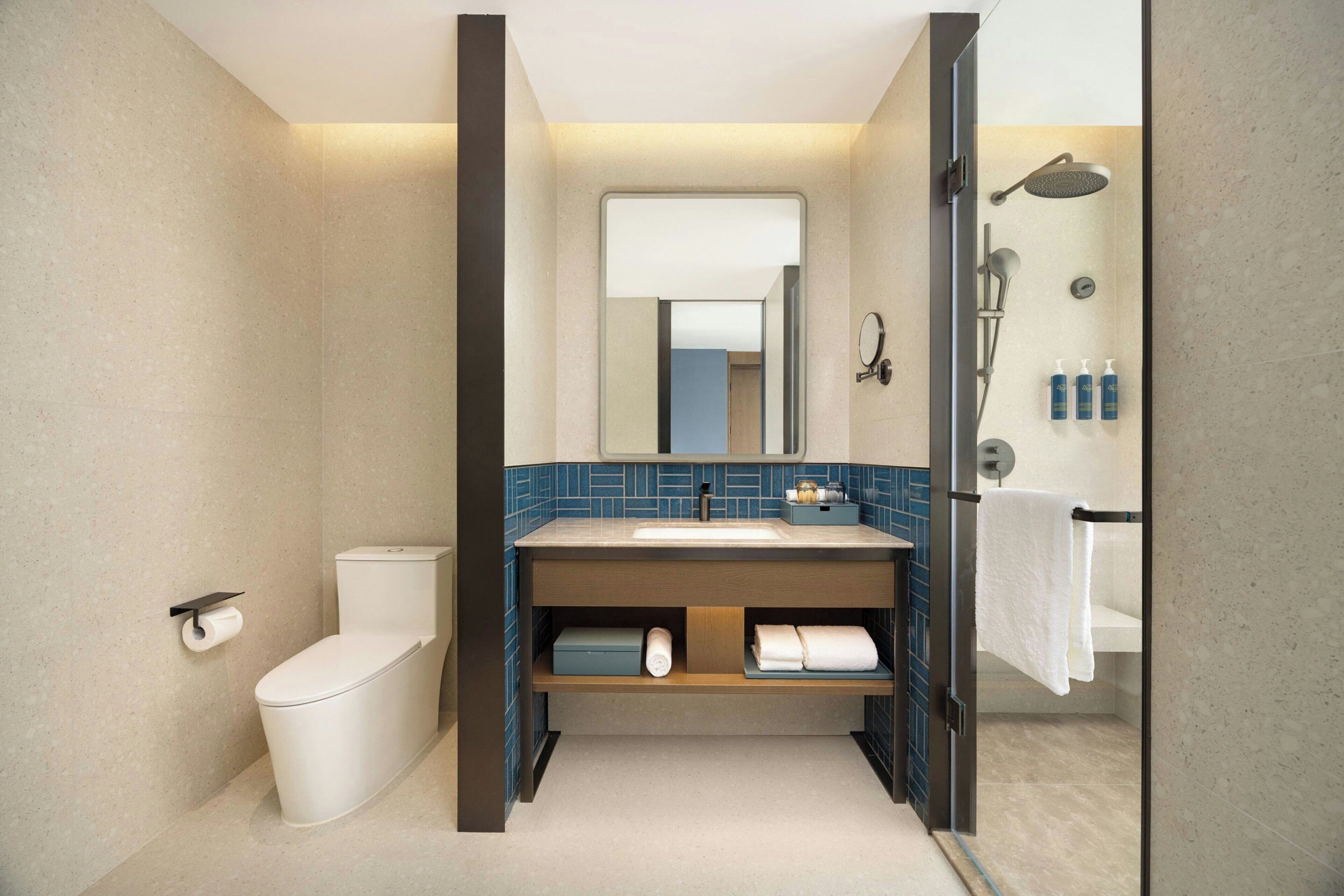 A modern bathroom with a toilet, sink, and shower.