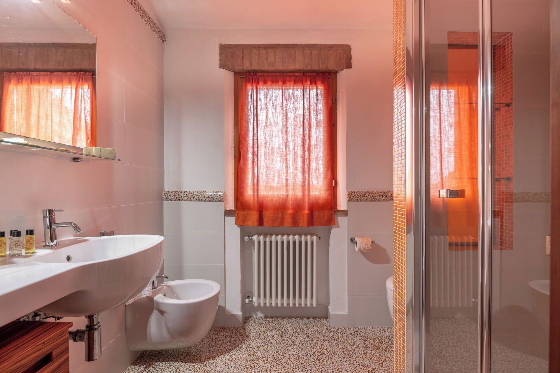 Un baño con lavamanos, bidé y zona de ducha.
