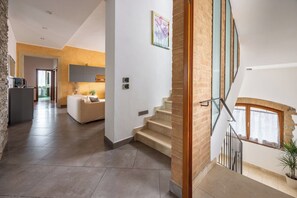 Ein modernes Interieur mit Treppe, Wohnbereich und Küche.