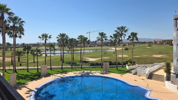 A swimming pool with a view of a golf course and palm trees. - Cozy apartment in Murcia (Murcia)
