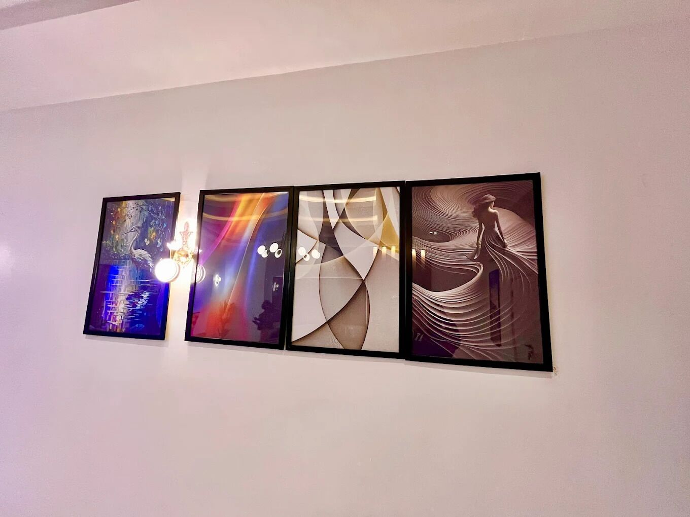 A wall with four framed artworks.