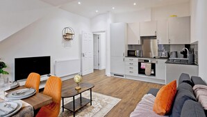 Een modern appartement met een eetgedeelte, een woonkamer en een keuken.