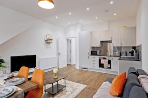 A modern apartment with a dining area, a living room, and a kitchen. - Imperial Woodberry Grove Apartments (London)
