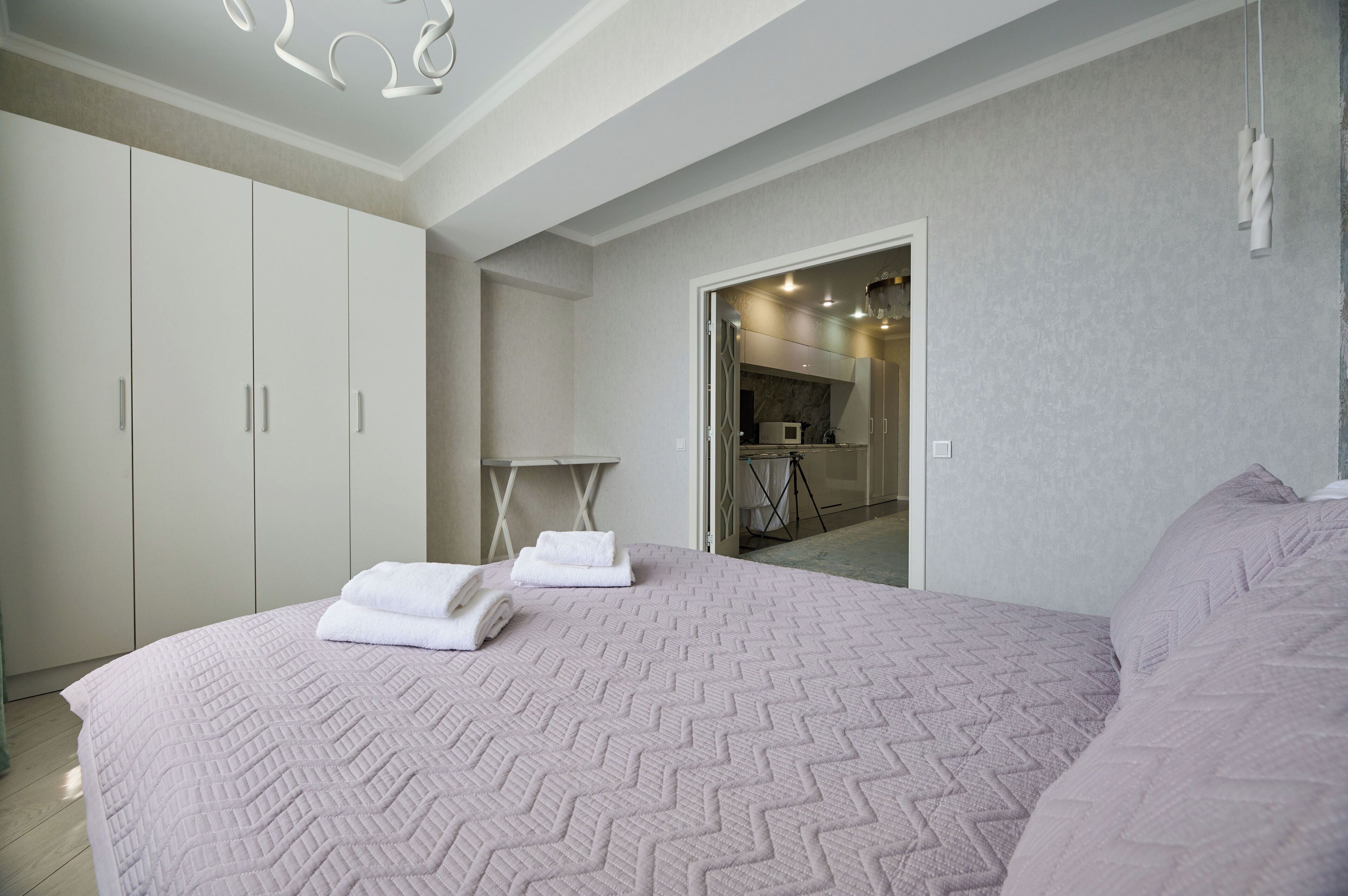 Camera da letto con un letto grande, un armadio e una piccola cucina sullo sfondo.